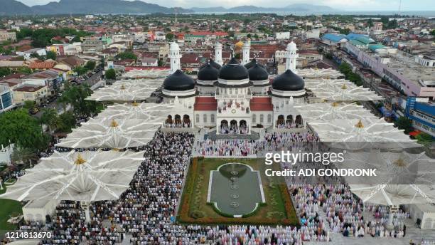 An aerial photograph shows people attending Eid al-Fitr prayers, marking the end of the Muslim holy month of Ramadan at Baiturrahman Mosque in Banda...