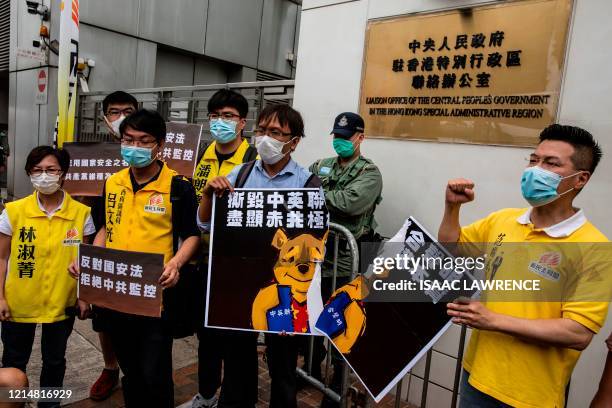 Pro-democracy activists tear a placard of Winnie-the-pooh that represents Chinese President Xi Jinping during a protest against a proposed new...
