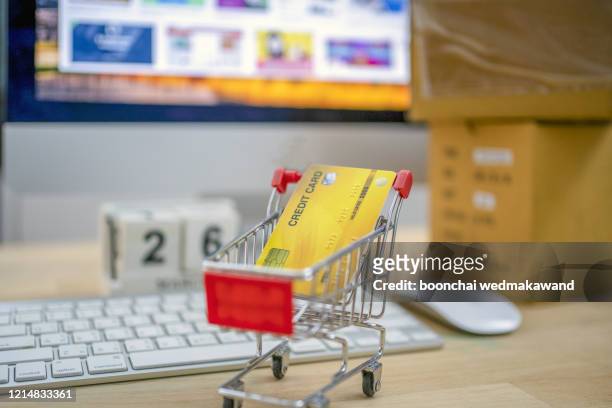 shopping cart and credit card on computer, shopping online concept. subject is blurred and low key. - post game stock-fotos und bilder
