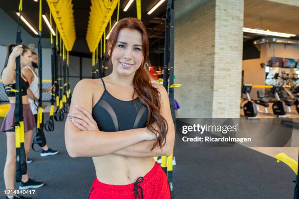 latina woman looks at the camera while standing in a gym aerobics room - entrenar stock pictures, royalty-free photos & images