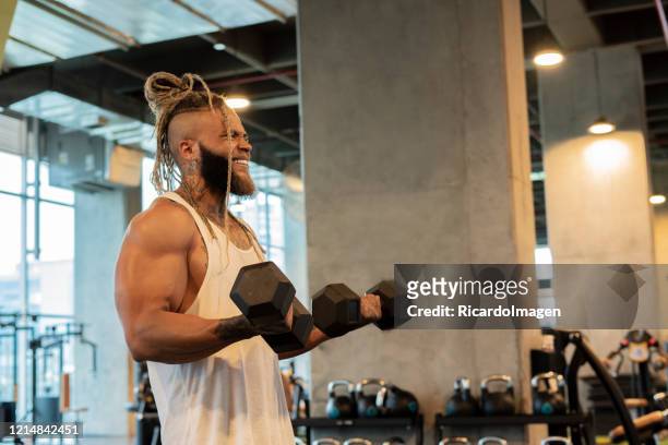 latino man exercises his arms with the help of weights - entrenar stock pictures, royalty-free photos & images