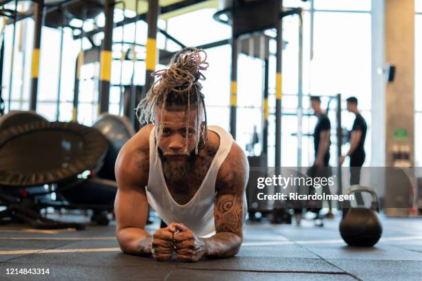 latino man exercises his arms with the help of his own weight - entrenar stock pictures, royalty-free photos & images