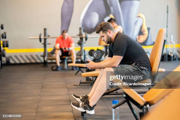 mens die in de gymnastiek rust - entrenar stockfoto's en -beelden