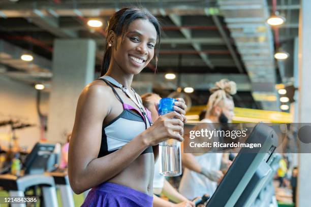 latin woman on gym treadmill - entrenar stock pictures, royalty-free photos & images