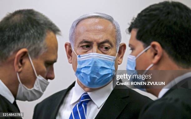 Israeli Prime Minister Benjamin Netanyahu , wearing a protective face maks, speaks with his lawyer inside a courtroom at the district court of...