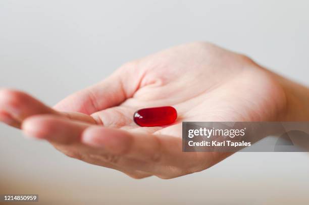 a sick person is taking a pill - red pill stock pictures, royalty-free photos & images