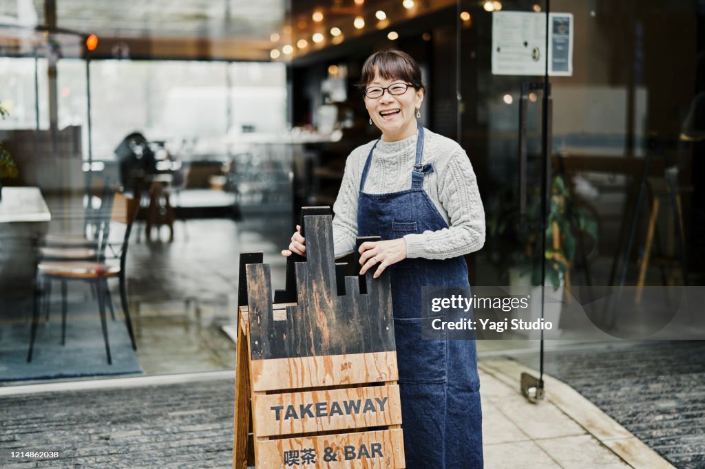 Senior female owner working in cafe