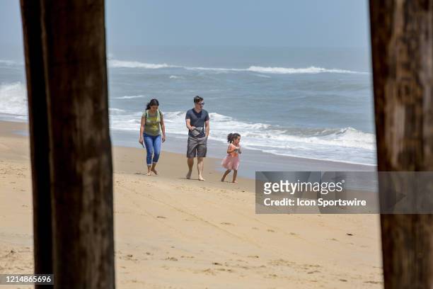 People walk along the shoreline near Virginia Beach Fishing Pier to kick off Memorial Day weekend on May 22 in Virginia Beach, VA. This is the first...