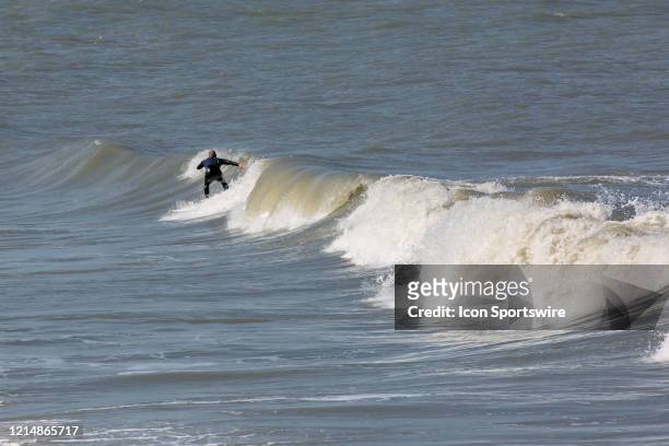 Surfer takes advantage of the rough waves left behind by Tropical Storm Arthur on May 22 in Virginia Beach, VA. This is the first day of the beach's...