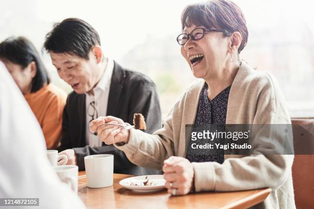 senior friends enjoying retirement party in cafe - japanese old woman stock pictures, royalty-free photos & images