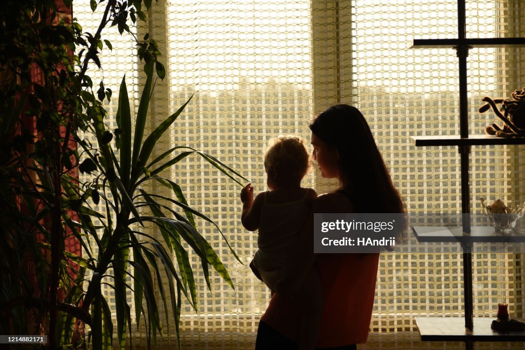 Mother with baby looking out the window.