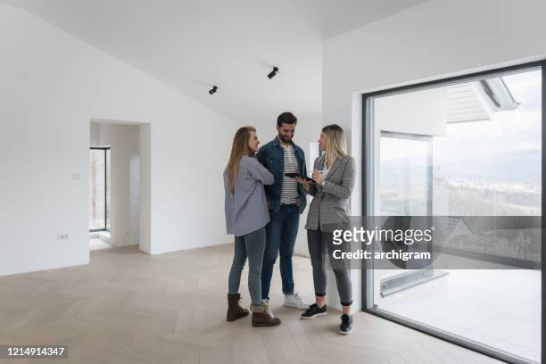 real estate agent with couple in luxury home - searching stock pictures, royalty-free photos & images