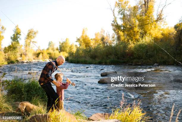father and son fishing together - park city stockfoto's en -beelden