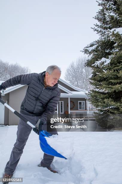 senior man shoveling snow - shoveling driveway stock pictures, royalty-free photos & images