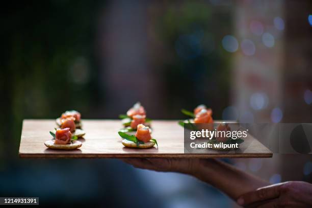 鮭魚開胃菜的鬆餅,具有分散的仙女燈背景 - canapé 個照片及圖片檔