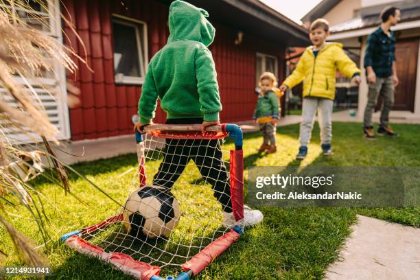 giocare a calcio in un cortile - baby football foto e immagini stock