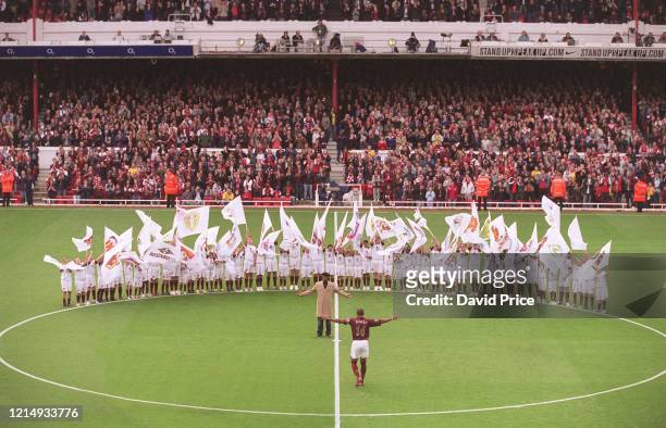 Thierry Henry of Arsenal walks to the centre circle to be greeted by former Arsenal player Ian Wright who was there to present him with a golden...