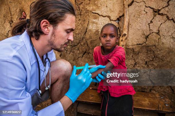 arzt macht eine injektion zu kleinen afrikanischen mädchen in einem kleinen dorf, kenia - doctors without borders stock-fotos und bilder