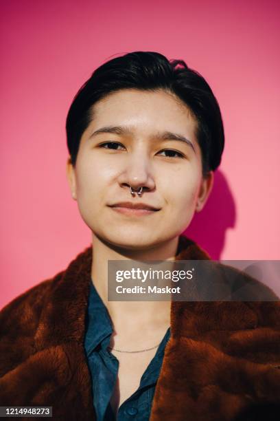 portrait of young woman against pink background - non binary stereotypes stock pictures, royalty-free photos & images