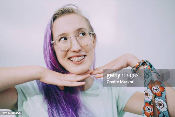 smiling teenage girl with braces standing against white background - cabello morado fotografías e imágenes de stock
