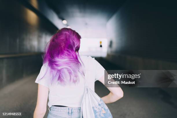 rear view of teenage girl standing in corridor - cabello morado fotografías e imágenes de stock