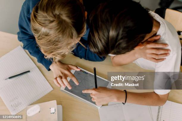 high angle view of male students using digital tablet in classroom - innocence stockfoto's en -beelden