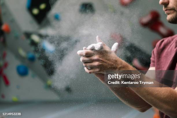 midsection of man dusting powder in gym - bouldering - fotografias e filmes do acervo
