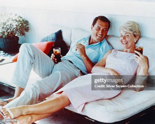 Rock Hudson , US actor, wearing white trousers and a light blue short-sleeved shirt, and Doris Day, US singer and actress, in a pink gingham dress,...