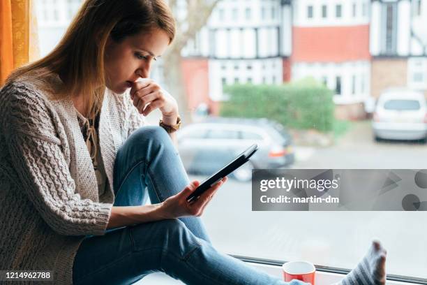 social distancing during covid-19 pandemic - surprised woman looking at tablet stock pictures, royalty-free photos & images