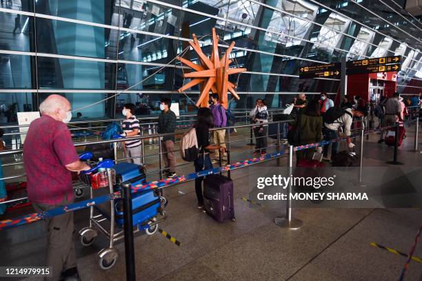Passengers lineup to check-in outside the Indira Gandhi International airport during the first day of resuming of domestic flights after the...