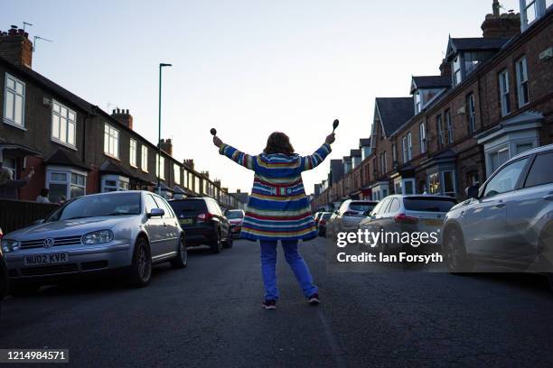 Woman dances outside her house as residents of Leven Street in Saltburn By The Sea gather in their doorways, front gardens and street outside their...