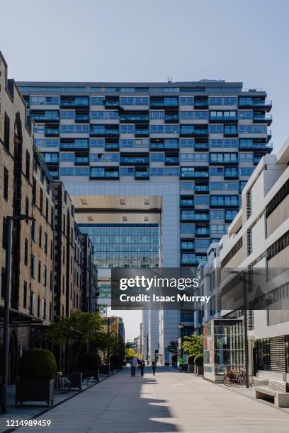 people walk down long pedestrian walkway under the kranhaus modern architecture - superior council stock pictures, royalty-free photos & images