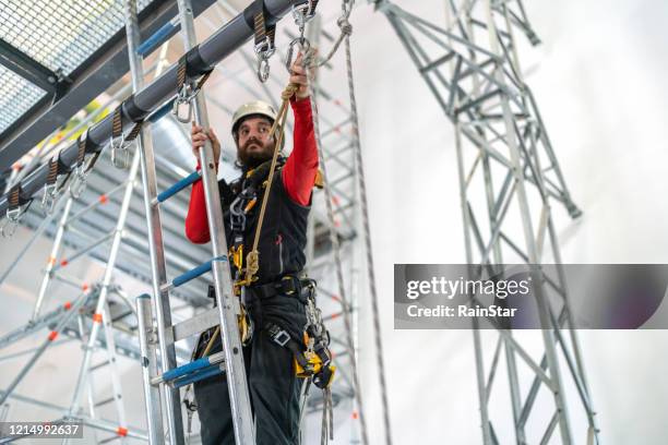 tough climb - safety harness stock pictures, royalty-free photos & images