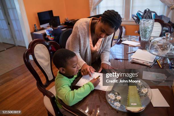 Geri Andre-Major helps her son Max with his school work on March 26, 2020 in Mount Vernon, New York. Andre-Major said she was furloughed as a...