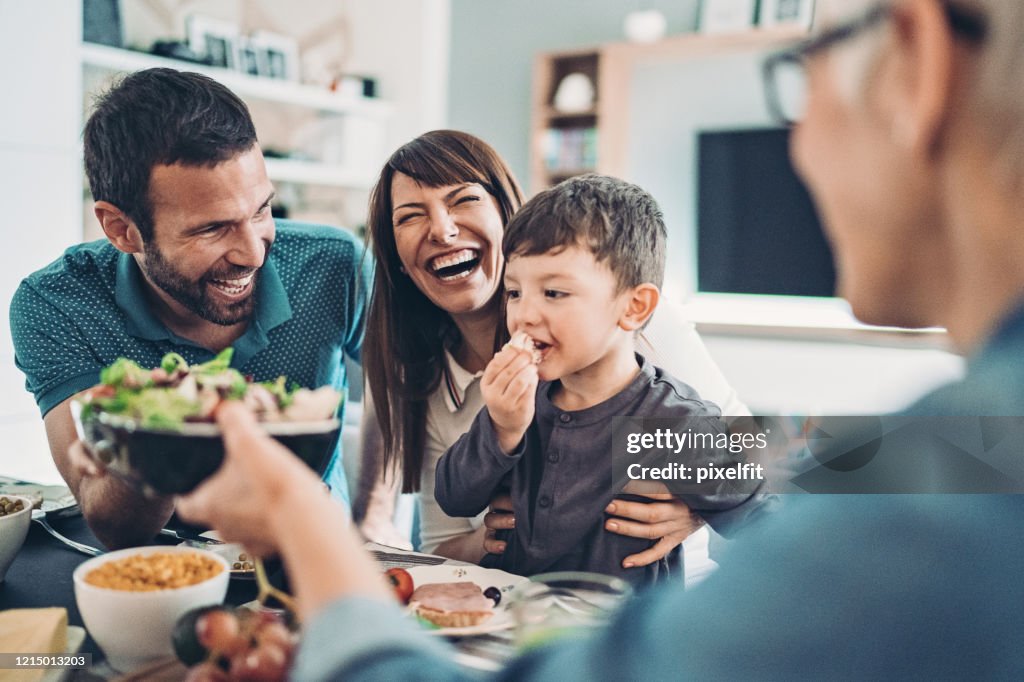 Großmutter, Mutter, Vater und ein Junge beim Mittagessen