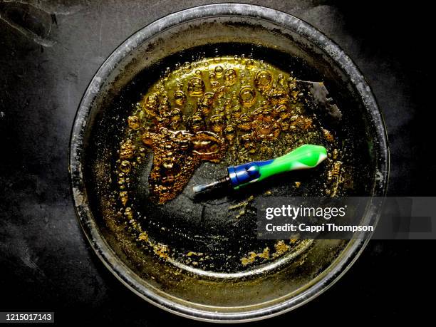 cannabis concentrate hash oil with dab stick and razor blade - hashish stockfoto's en -beelden