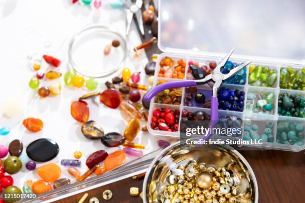 close-up photo of multiple colored beads with a pair of needle nose pliers - bead foto e immagini stock