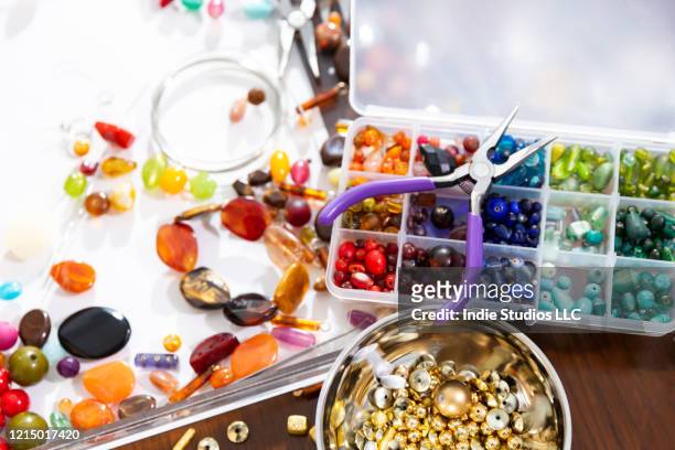 close-up photo of multiple colored beads with a pair of needle nose pliers - making jewelry stockfoto's en -beelden