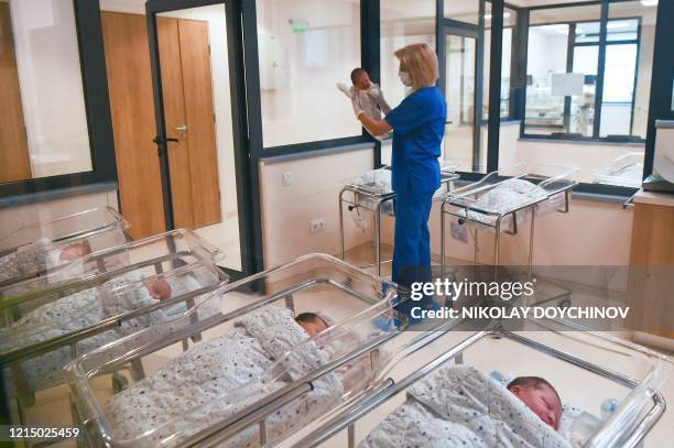 Neonatologist Valentina Gerginova holds a newborn prior to administering a dose of BCG vaccine in Vita private hospital in Sofia on May 20, 20120. -...