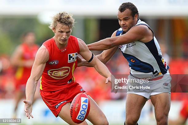 Trent McKenzie of the Suns and Graham Johncock of the Crows compete for the ball during the round 22 AFL match between the Gold Coast Suns and the...