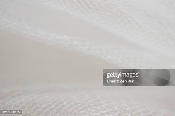 selective focus on white tulle fabric in monochrome - tulle en matière textile photos et images de collection