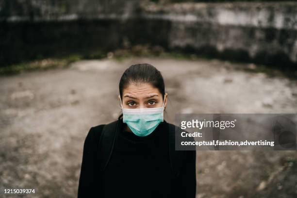 patient suffering from infectious disease,sick person in mask.scared woman suffering from symptoms of illness.patient in isolation,alone in deserted unpopulated place.incurable infectious disease - lepra stock-fotos und bilder