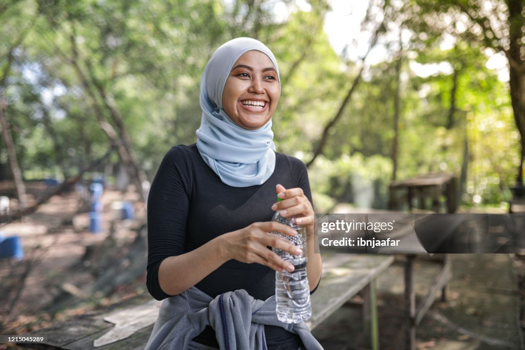 Young people hijab women resting and drink water at park