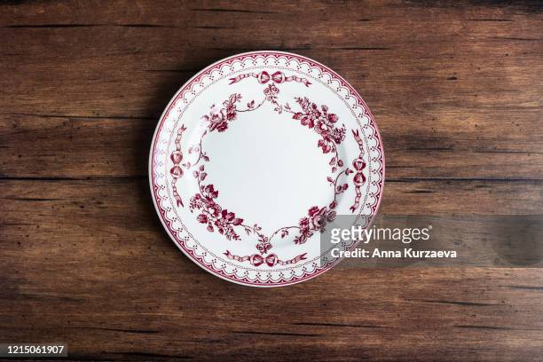 empty plate with floral pattern on an old wooden brown background, top view. image with copy space. kitchen table with a plate - top view with copy space. - rustic plate overhead photos et images de collection