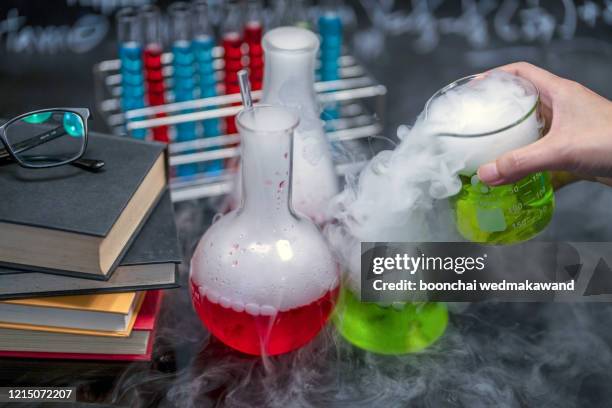 laboratory glassware with solutions of different colors on table - chemical reaction stock pictures, royalty-free photos & images