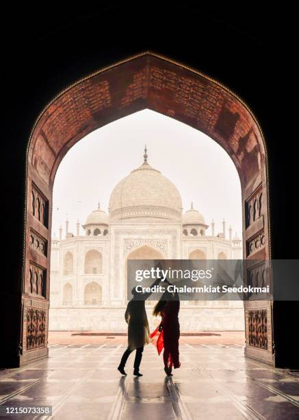 a man dancing with woman with the view of taj mahal in agra, india - couple india stock-fotos und bilder