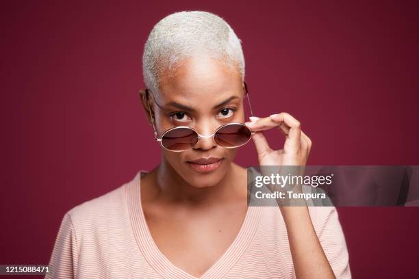 junge hispanische frau porträt mit sonnenbrille. - über etwas schauen stock-fotos und bilder