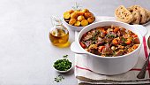 Beef bourguignon stew with vegetables. Grey background. Copy space.