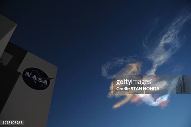 Contrails from the space shuttle Discovery are seen near the Vehicle Assembly Building just after launch on April 5, 2010 at the Kennedy Space Center...