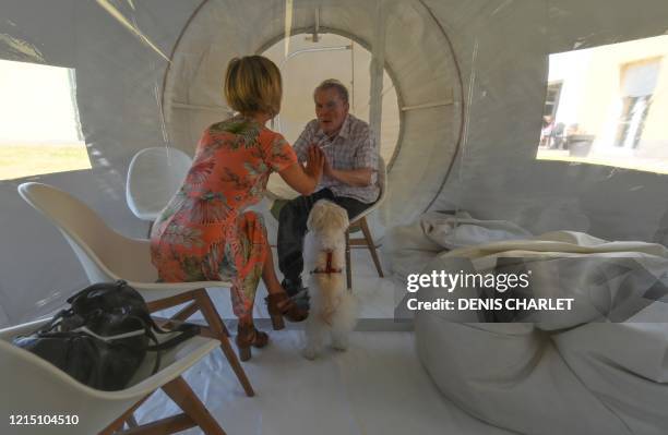 Woman visits her husband on May 25, 2020 at a retirement home in Bourbourg , where a double entry bubble has been installed to allow visits without...